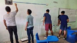 Estudiantes realizando labor social de pintura a la escuela 